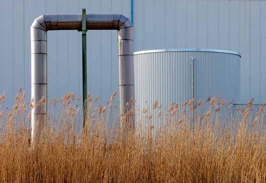 Fernwärmerohr vor einem großen Kessel